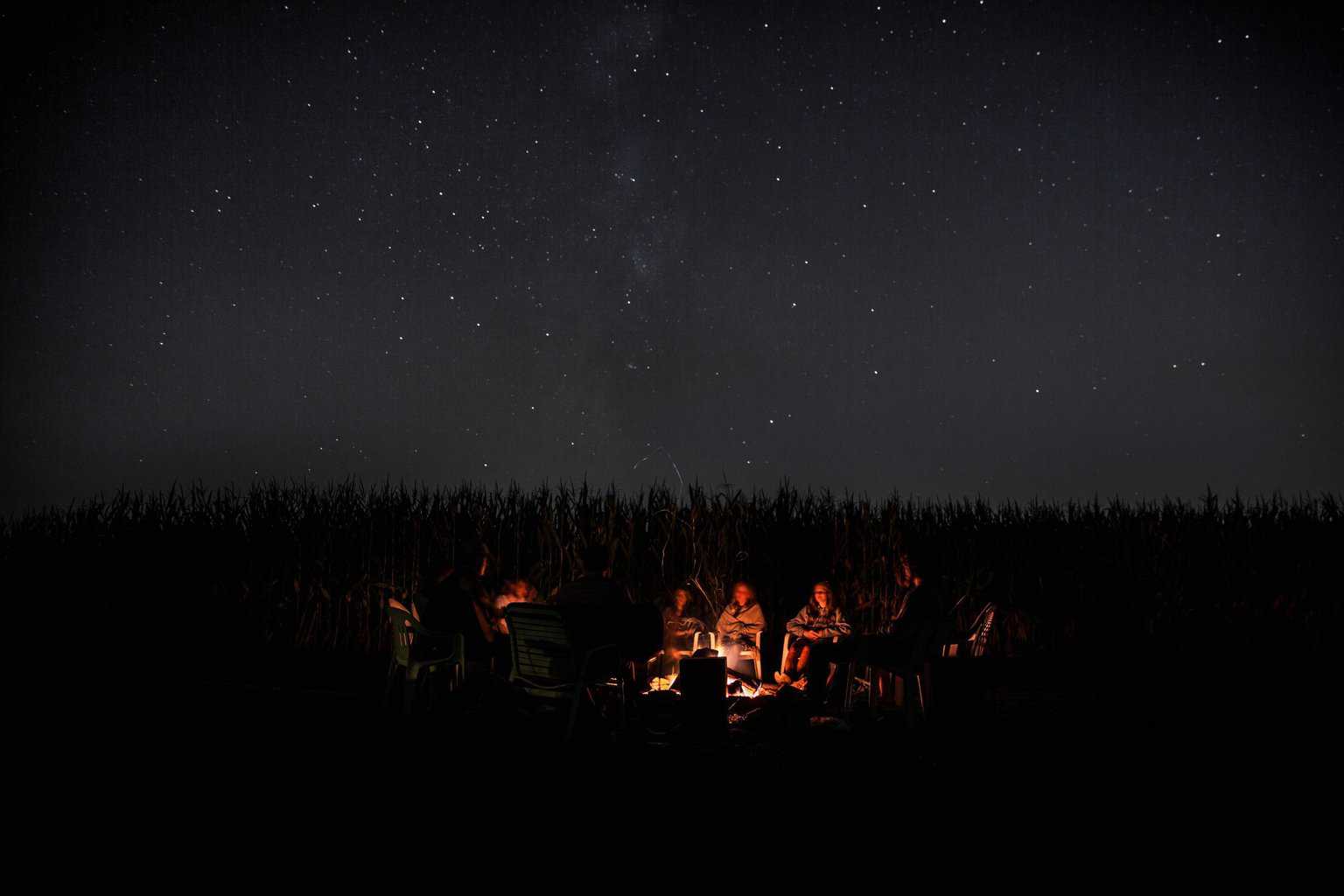 Eine Gruppe sitzt am nächtlichen Lagerfeuer und erzählt sich Geschichten.